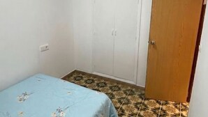 A bedroom with a bed, wardrobe, and a wooden door. - Charming Holiday House in Almazora (Almassora)