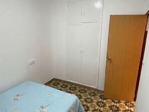 A bedroom with a bed, wardrobe, and a wooden door. - Charming Holiday House in Almazora (Almassora)