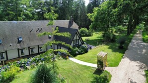 A traditional Tudor-style building with a well-maintained garden and a gravel path.