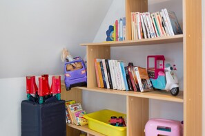 A bookshelf with books and children's toys.