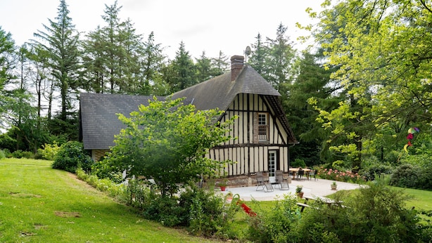 Ett traditionellt hus med korsvirkesfasad, en trädgårdsterrass och utomhusmöbler.
