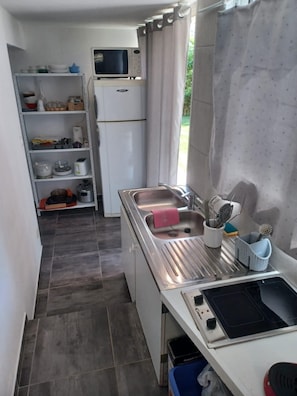 Eine kleine Küche mit Mikrowelle, Spüle und einer Essecke.
