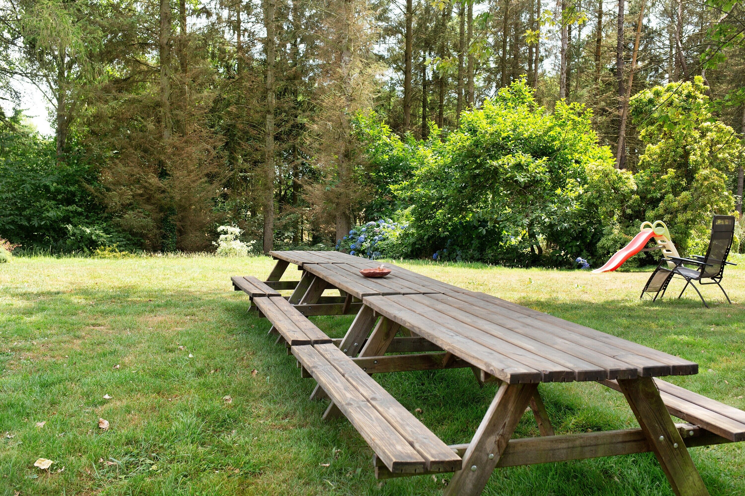Ein Picknickbereich mit Holzbänken und einer Rutsche.