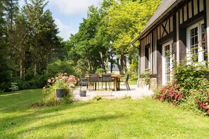 Un bâtiment traditionnel doté d’un patio avec jardin, entouré d’une végétation luxuriante et d’arbres.