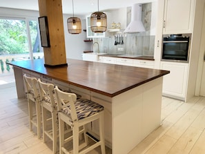 A kitchen with a large island, white cabinetry, a built-in oven, and pendant lighting. - Unique vacation home—just a 2-minute walk to the beach! (Playa de Muro)