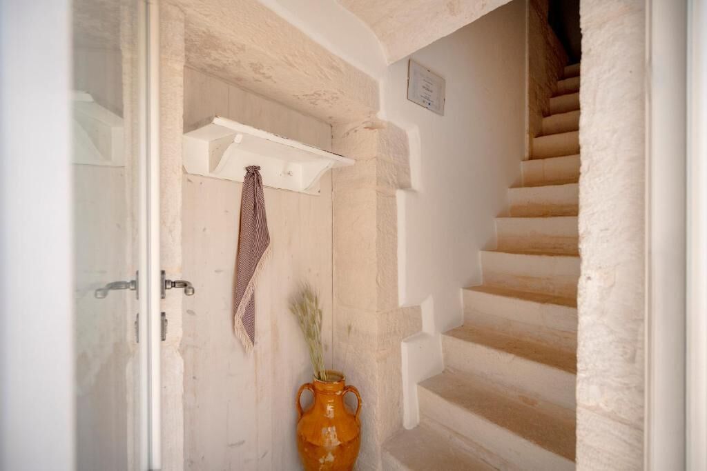 Un escalier avec un mur blanc et une porte en bois.
