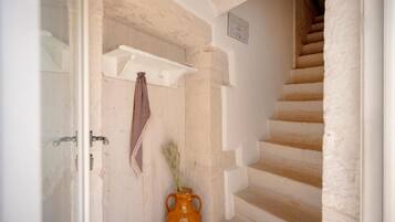 Un escalier avec un mur blanc et une porte en bois.