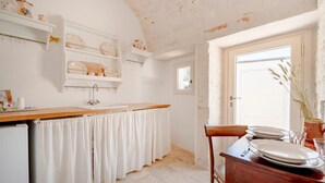 Een keuken met witte kasten, een houten aanrecht en een witte spoelbak.