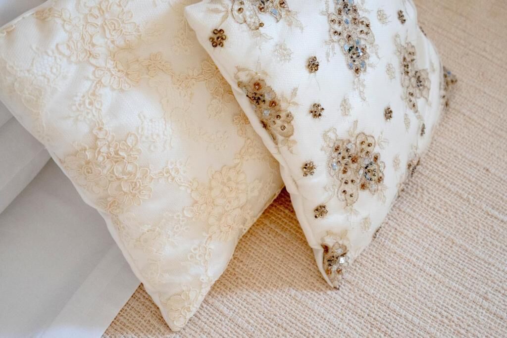 Two pillows with floral embroidery on a textured fabric surface.