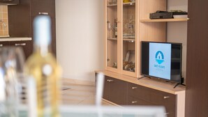 Eine moderne Küche mit integriertem Fernseher, einem Weinschränkchen und einem Holzkasten mit Schubladen.