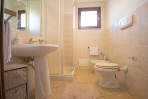 Un baño con lavamanos, inodoro y ducha.