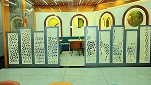 A reception area with a modern design, featuring a reception desk, seating area, and decorative panels. - Gehlot Paradise Hotel (Nagaur)