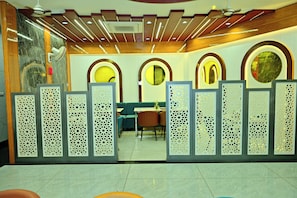 A reception area with a modern design, featuring a reception desk, seating area, and decorative panels.