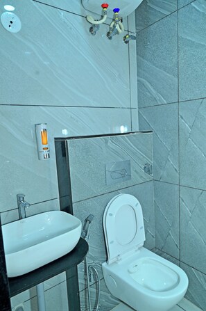 Une salle de bain moderne avec un lavabo, des toilettes et un miroir.