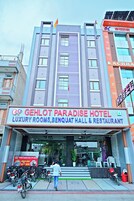 Un hotel con un cartel que dice 'GEHLOT PARADISE HOTEL' y 'HABITACIONES DE LUJO, SALÓN DE BENQUAT Y RESTAURANTE'.