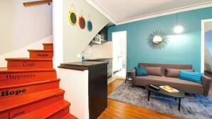 Una escalera con escalones etiquetados 'Verdad', 'Felicidad', 'Esperanza' y 'Amor', que conduce a una zona de cocina.