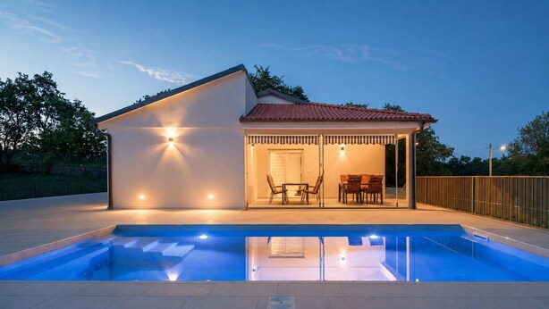 A modern house with a swimming pool, a covered patio with outdoor furniture, and a well-lit entrance. - Family house with pool (Divsici)