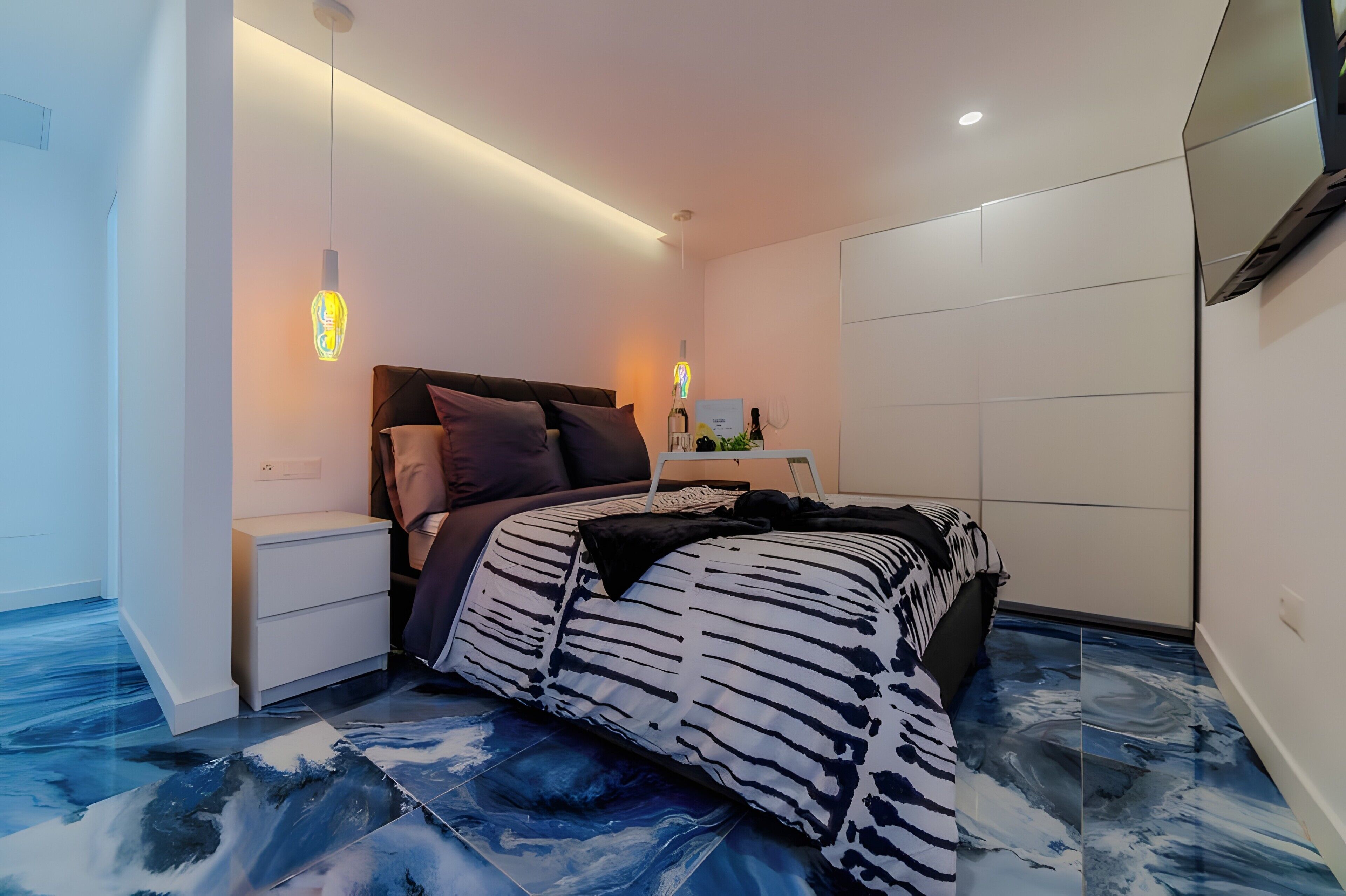 A modern bedroom with a bed, bedside tables, and a nightstand.