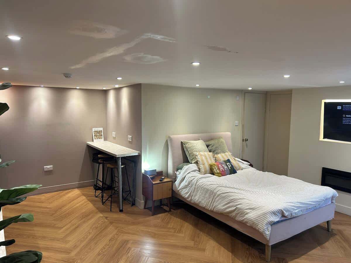 A bedroom with a bed, a desk, and a chair.