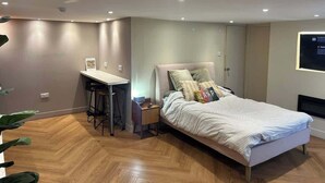 Un dormitorio con una cama, un escritorio y una silla.