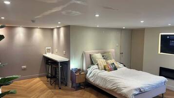 A bedroom with a bed, a desk, and a chair.