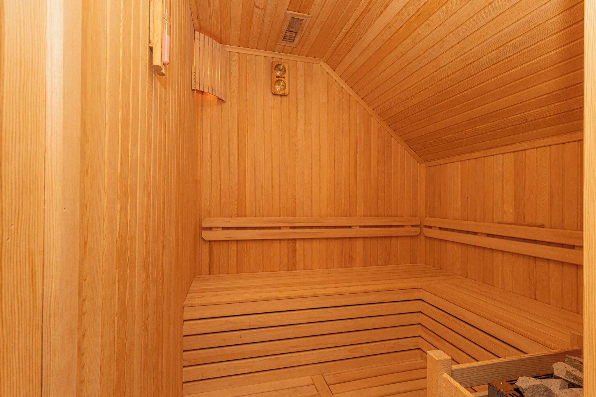 Un sauna en bois avec des bancs et une banquette.