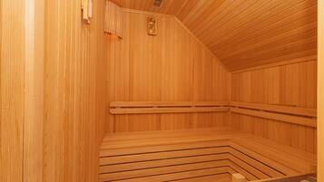 Un sauna en bois avec des bancs et une banquette.