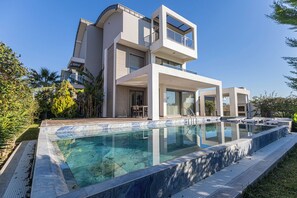 Una moderna casa a due piani con piscina.