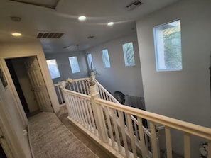 A staircase with a white railing, a door at the bottom, and a window on the right. - 1-bedroom bed & breakfast in delightful Las Vegas with AC (Las Vegas)