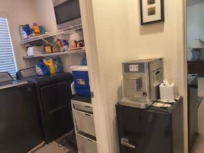 Una habitación compacta con kitchenette, un refrigerador pequeño, un microondas y una cafetera.