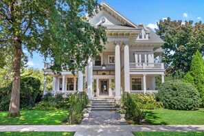 Un'ampia casa a due piani con portico, colonne e facciata simmetrica.