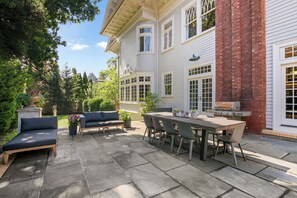 Un patio con tavolo, sedie, barbecue e divano.