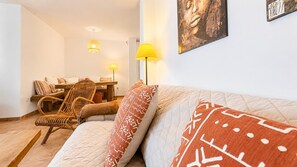 A bedroom with a bed, a chair, a table, and a lamp. - Casa Vega Vera Playa | Primera Línea de Playa | Beachtfront luxury Apartment with garden (Vera Playa)
