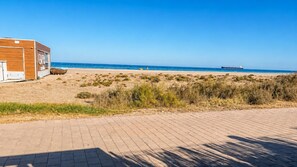 A beachside building with a paved walkway leading to the ocean. - Casa Vega Vera Playa | Primera Línea de Playa | Beachtfront luxury Apartment with garden (Vera Playa)