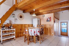 Ein Essbereich mit Holztisch und Stühlen, einer Tafel und einem Kühlschrank.