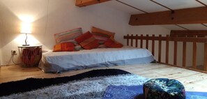 A small, cozy room with a bed, a lamp, and a wooden headboard.