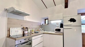 A modern kitchen with white cabinets, a microwave, a toaster, and a sink.