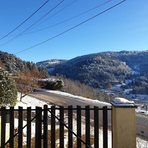 Paisagem rural com estrada, cerca de madeira e árvores cobertas de neve.