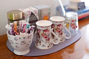 A set of floral-patterned cups and saucers on a table with a woven placemat.