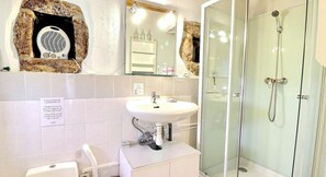A bathroom with a white sink, a glass shower enclosure, and a mirror with a decorative frame. - Guest Room “L’Adrienne” with Shared Garden and Wi-Fi (Chazeaux)