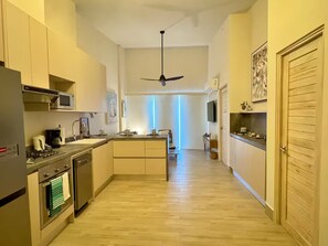 Eine moderne Küche mit Kochinsel, integrierten Geräten und Deckenventilator.