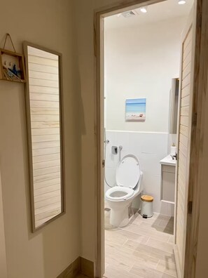 Un bagno con un water, un bidet e un piccolo cestino.