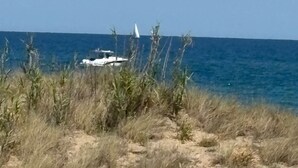 A coastal landscape with a sandy foreground, a clear blue sky, and a distant view of the ocean. - Naturist Village - Heliopolis AB - 30 m² - ocean view (Agde)
