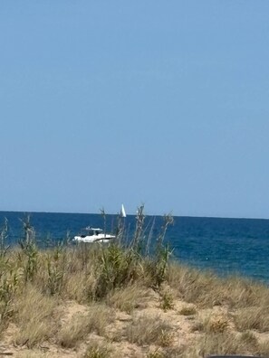 A coastal landscape with a sandy foreground, a clear blue sky, and a distant view of the ocean. - Naturist Village - Heliopolis AB - 30 m² - ocean view (Agde)
