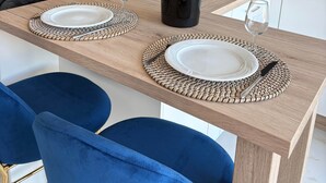 A modern kitchen with a dining table set for two, a refrigerator, and a microwave. - Naturist Village - Heliopolis AB - 30 m² - ocean view (Agde)