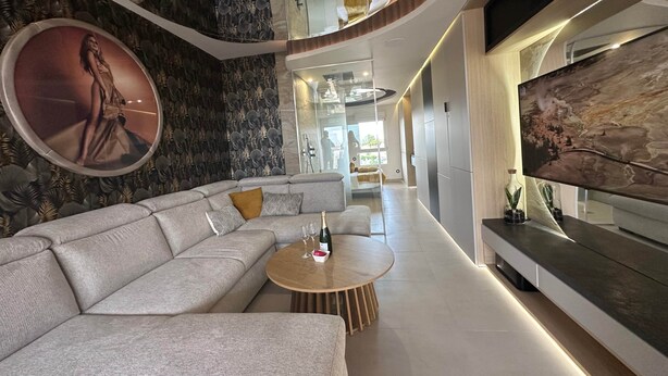 A modern living room with a sectional sofa, a round coffee table, and a large flat-screen TV. - The Bb Port Nature Coursives (Agde)