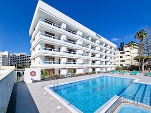 A modern hotel with a pool, multiple balconies, and a clear blue sky. - Apartamentos Fayna (Gran Canarias)