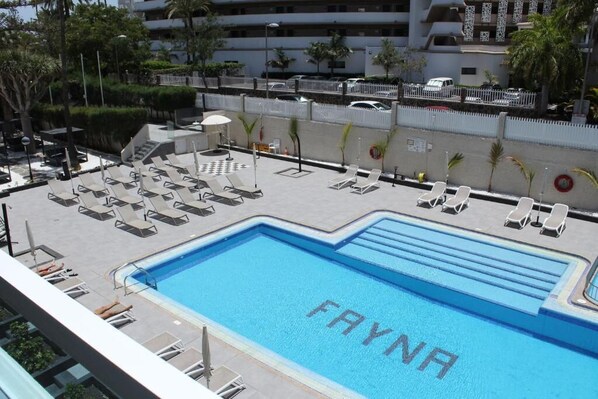 A pool area with lounge chairs and a pool labeled 'FAYNA.'