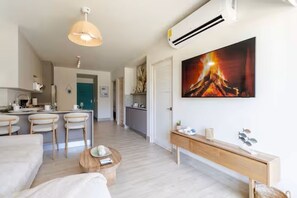A modern living area with a dining set, a coffee table, and a painting of a fire. - Exclusivo apartamento con vista a la piscina (punta chame)