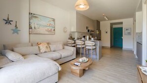 Una sala de estar con sofá, mesa de centro y un cuadro en la pared.